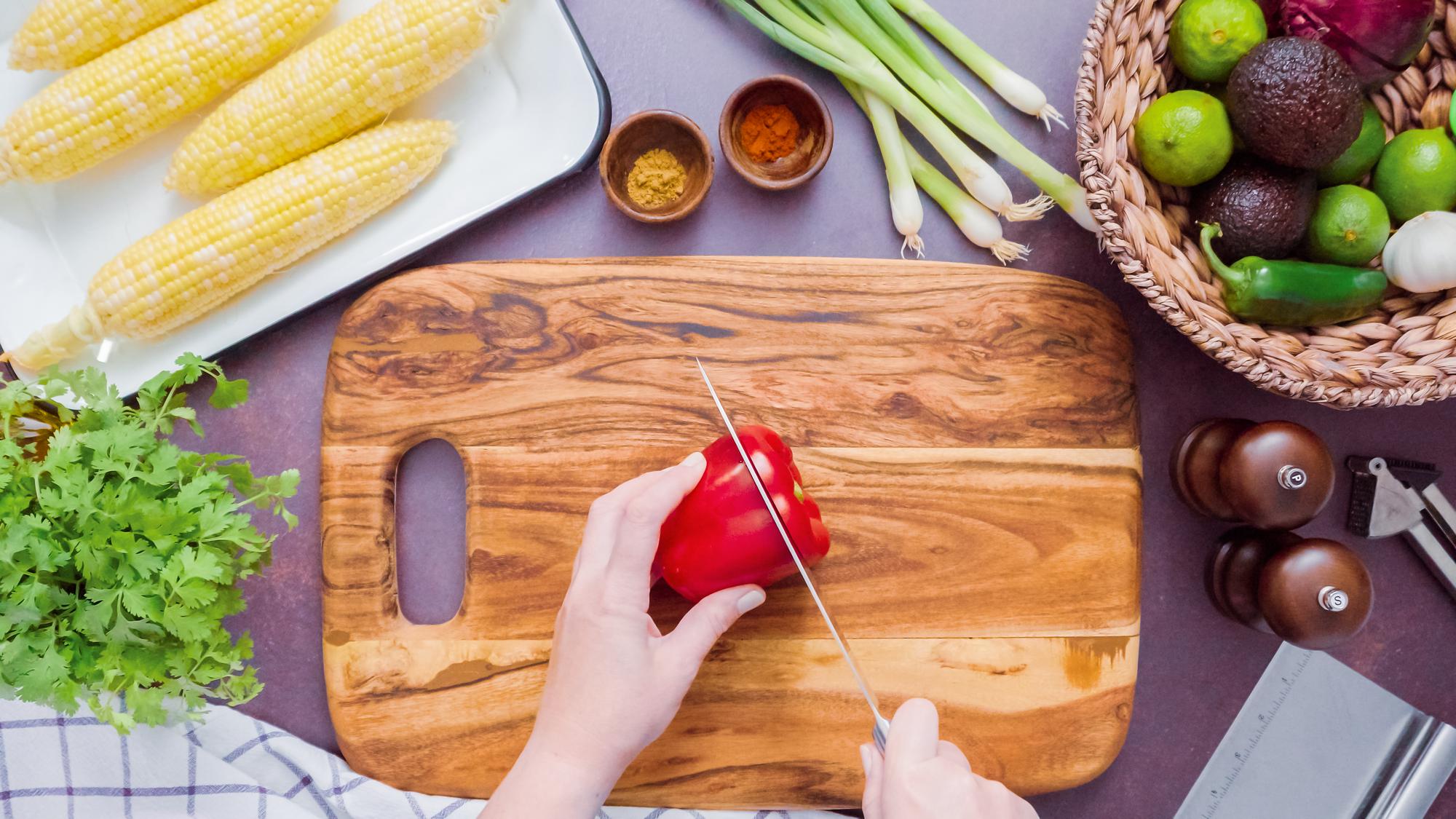 Hands preparing vegetables on kitchen counter